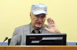 Defiance with a Smile: Mladic Faces Genocide Survivors in Court