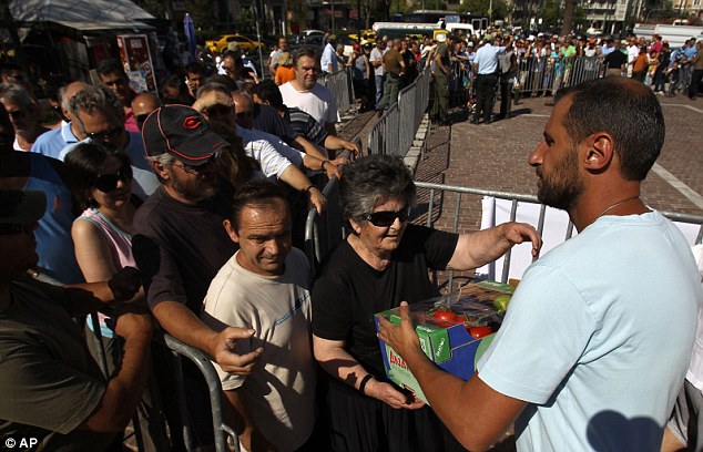 Greek citizens line up for the food donations being handed out by farmers